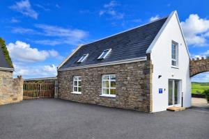 a detached stone house with a garage at Aran View Holiday Homes - The Courtyard Suite - Cozy for two in Doolin