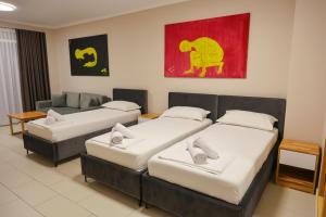 a room with three beds and a couch at Hotel Adria in Shëngjin