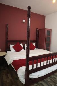 a bedroom with two beds with red and white pillows at Rakas Guest House Ooty in Ketti +13 photos