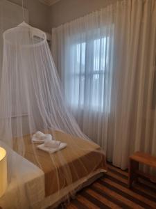 a bedroom with a bed with a mosquito net at Chalé Quitxiba in São Tomé +42 photos