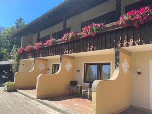 a building with a balcony with flowers on it at Bergbauern Wirtshaus in Kötschach +9 photos