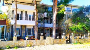 a building with palm trees in front of it at Haluk Otel in Oren
