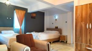 a bedroom with two beds and a chair and a couch at Haluk Otel in Oren