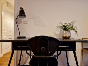 a desk with a chair with a lamp and a plant at Stylish Spacious Serviced Apartment next to City Centre with Free Parking - Contractors & Relocators in Coventry