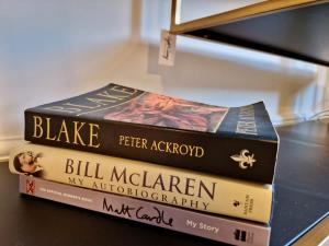 three books stacked on top of each other on a shelf at Stylish Spacious Serviced Apartment next to City Centre with Free Parking - Contractors & Relocators in Coventry