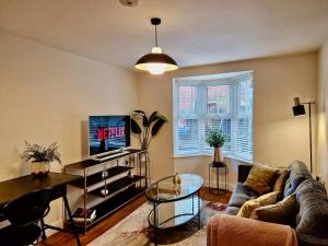 a living room with a couch and a table at Stylish Spacious Serviced Apartment next to City Centre with Free Parking - Contractors & Relocators in Coventry +14 photos