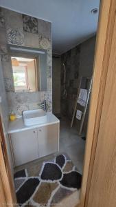 a bathroom with a sink and a mirror at Semelia & Maria's Guest Houses - Cozy Stay for 2 in Spata