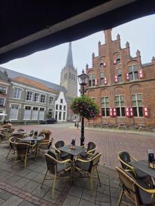a courtyard with tables and chairs and a building at Bij de Kerk in Doesburg