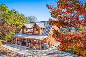 a log home with a gambrel roof at Bearfoot Pines - True Log Cabin - Wi-Fi, Hot Tub, Fishing, Deck with views! - Mins to PF in Sevierville