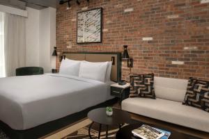 a bedroom with a bed and a brick wall at The Livingston, part of JdV by Hyatt in Brooklyn