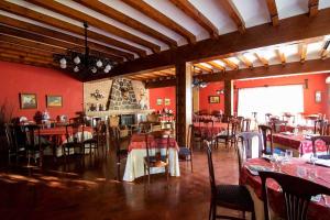 a restaurant with red walls and tables and chairs at Hotel Recio in Santa Olalla de Toledo