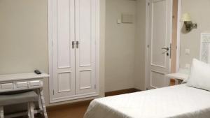 a white bedroom with a bed and a desk at Hotel Recio in Santa Olalla de Toledo +4 photos