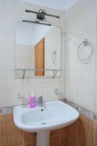 a bathroom with a white sink and a mirror at Hotel Brahimi in Gjirokastër