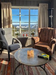 a living room with a couch and a table at Cabin With Panoramic Views Over The Mountains in Nesbyen
