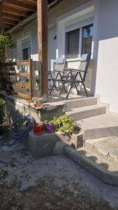 a porch with a chair and some plants at Semelia & Maria's Guest Houses - Cozy Stay for 2 in Spata +9 photos
