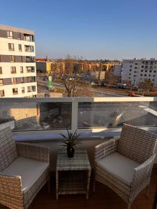 a balcony with chairs and a view of a city at The Gold Resident Airport Warszawa-Modlin in Nowy Dwór Mazowiecki