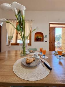 a table with a vase of flowers and a plate of food at Villa Irmā in Tertenìa