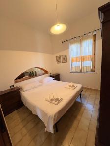 a bedroom with a large bed with white sheets at Villa Irmā in Tertenìa