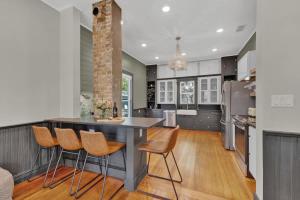 a kitchen with a large island with chairs in it at Historic Gem near Schlitterbahn in New Braunfels