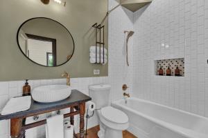 a bathroom with a tub and a toilet and a mirror at Historic Gem near Schlitterbahn in New Braunfels +21 photos