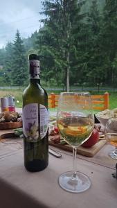 a bottle of wine and a glass on a table at Old Chalet Apuseni in Arada