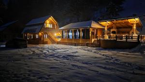 a house in the snow at night at Old Chalet Apuseni in Arada