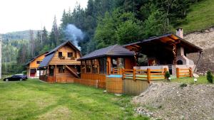 a log cabin with smoke coming out of it at Old Chalet Apuseni in Arada