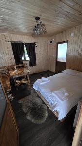 a bedroom with a large bed in a wooden room at Old Chalet Apuseni in Arada