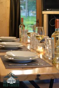 a table with plates and glasses and wine bottles at Old Chalet Apuseni in Arada +20 photos