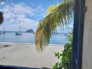 a window view of a beach with boats in the water at kolaille chambre HOTE numéro 42 in Saint-Pierre