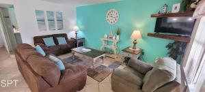 a living room with couches and a flat screen tv at Fiesta Sol #110 in South Padre Island
