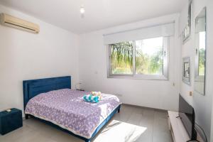 a bedroom with a bed with a teddy bear on it at Akefalou Bay Villa in Protaras +106 photos