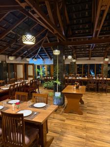 a restaurant with wooden tables and chairs in a room at Great Himalayan Resort in Dharmsāla