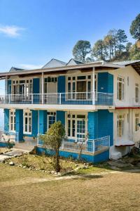 a blue house on the beach at Great Himalayan Resort in Dharmsāla