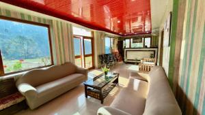 a living room with a couch and a fireplace at Great Himalayan Resort in Dharmsāla