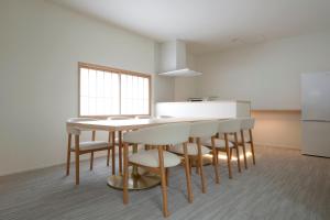 eine Küche mit Tisch, Stühlen und Kühlschrank in der Unterkunft JINRYU Hotel ISE in Ise + 34 Fotos