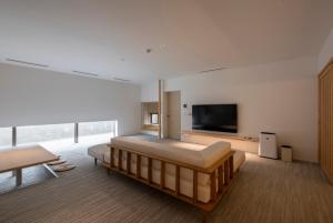 ein Schlafzimmer mit Bett und Flachbildfernseher in der Unterkunft JINRYU Hotel ISE in Ise