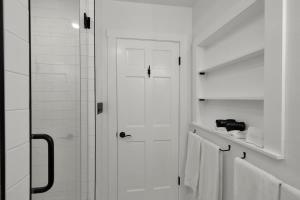 a white bathroom with a shower and white towels at Tejas Suite Walking Distance to Main St! in Fredericksburg