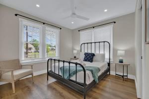 a bedroom with a bed and a chair and two windows at The Grove Combo in Fredericksburg +37 photos