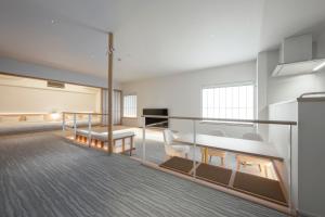 ein Zimmer mit Bett und Stühlen in einem Gebäude in der Unterkunft JINRYU Hotel ISE in Ise
