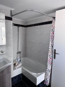 a bathroom with a bath tub and a sink at J&J spacious balcony apartment in Preveza