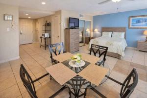 a room with a bed and a dining table and chairs at Great Pool - Beach Access - Small Family Perfect in South Padre Island