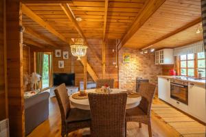 a kitchen and dining room with a table and chairs at Leśniczówka Białogóra & jacuzzi in Białogóra +30 photos