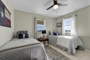 a bedroom with two beds and a ceiling fan at Casa Blanca: Hot-tub, Fire Pit, Hill Country Views in Luckenbach