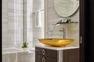 a bathroom with a gold sink and a tub at Mirax Sapphire Boutique Hotel in Kharkiv