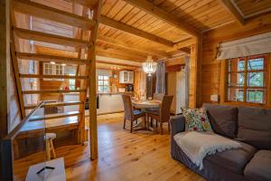 a living room and dining room of a log cabin at Leśniczówka Białogóra & jacuzzi in Białogóra