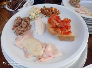 a plate of food with meat and bread on a table at Locanda Tarello 1880 in Roppolo