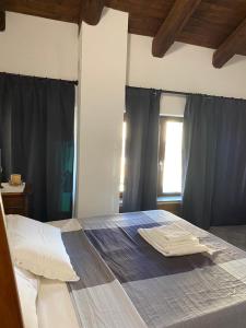 a bedroom with a large bed with black curtains at Locanda Tarello 1880 in Roppolo
