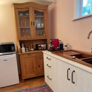 a kitchen with wooden cabinets and a counter top at Wisteria Cottage in Russell