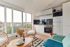 a living room with a couch and a table at Charmant T2 - 2min de Lille in Ronchin